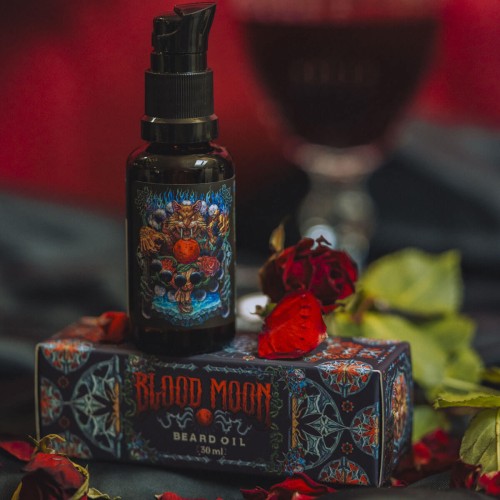 Olejek-do-brody-w-ciemnej-butelce-z-aplikatorem,-z-nadrukiem-graficznym-przedstawiajacym-mistyczne-elementy.-Na-pudelku-widoczny-napis-„BLOOD-MOON-w-czerwonym-kolorze.-Produkt-lezy-na-czarnym-tle,-otoczony-platkami-roz-i-zielonymi-liscmi..jpg